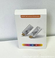 Front of packaging showing graphic of two white HDMI Wireless Extender units and feature highlights.