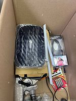 TP-Link black electronic device, wired headphones in packaging, Panasonic batteries, power plug adapter, and a long antenna or rod-like component.