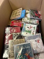 Top view of box showing Christmas dinner napkins, decorative snowflake buttons and some boxed cards.
