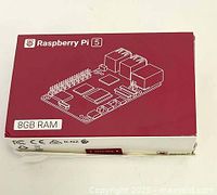 Closed retail packaging box for Raspberry Pi 5 showing branding and 8GB RAM.