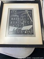 Framed black ink woodcut print showing Depression Era street scene with buildings, pedestrians, and telephone pole, signed by artist.
