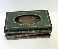 Front angle view of a green vintage book-inspired wooden tissue holder with oval top opening