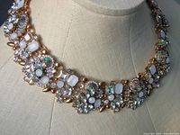 Front close-up of the colorful Aurora Borealis rhinestone necklace on a display bust, showing the multi-shaped stones set in gold-tone metal.