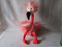 Front facing view of Jelly Cat flamingo plush toy sitting upright, showing fluffy feathers and detailed beak.