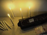 Photo showing multiple white LED floating candles standing upright with some turned on, along with a wand and envelopes on the table.