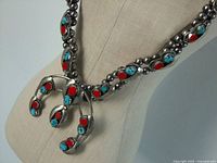 Front view of necklace on mannequin showing overall design and Naja pendant