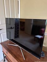 Side view of Samsung 42-inch TV on a wooden surface, showing the screen and sleek design.