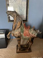 Side view of the polychromed Chinese horse sculpture showing detailed saddle and aging signs.