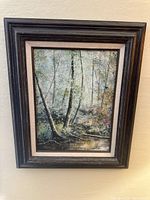 Framed oil painting showing a wooded California landscape with a stream.