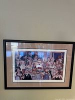 Full view of the framed lithograph showing a large dinner party scene with many caricatured figures around a table.