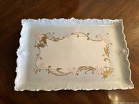 Full top view of rectangular scalloped platter showing floral decorations and embossed edge detail.