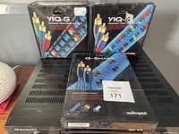 Two Audioquest YIQ-G component video cables in original boxes with visible product branding and fully sealed packaging next to a boxed Audioquest CinemaQuest G-Snake cable.