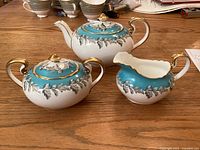 Full set of Aynsley Oak Leaf Turquoise teapot, sugar bowl, and creamer on wood table