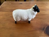 Side view of the Beswick ram figurine showing the detailed textured wool and black face with cream curved horns.