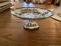 Porcelain footed dish standing on wooden table showing the detailed pattern and footed base.