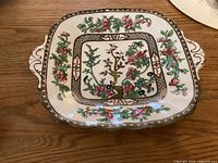 Top view showing the full decorated surface with colorful floral Indian Tree pattern and two handles.