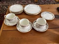 Set of Royal Doulton dinnerware arranged showing 8 large plates, 5 smaller plates, 3 cups on saucers, and an extra saucer.