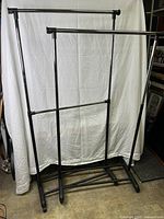 Full view of the double clothing rack with two hanging bars against white backdrop