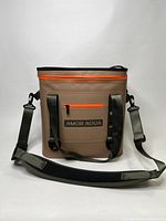Front view of brown synthetic insulated cooler bag with orange zipper and green adjustable shoulder strap, showing Amor Aqua logo.