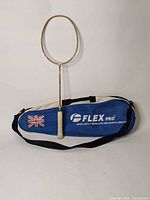 Flex Pro branded blue badminton bag with black shoulder strap and Union Jack flag patch, placed flat on surface.