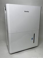 White Danby dehumidifier with visible water level window on front. Front view showing overall condition and branding.