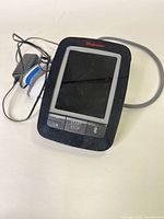 Top down image of the black Walgreens branded digital blood pressure monitor with start/stop and Bluetooth buttons visible, lying on a white surface.