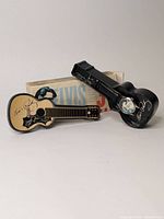 Two guitar shaped Elvis Presley 30th Anniversary watches, one in black guitar-shaped plastic case with signature and one outside case, along with original box.