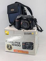 Nikon Coolpix 8400 camera displayed on top of original packaging box showing branding and camera model details.