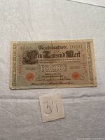 Front of the 1910 Reichsbanknote 1000 Mark showing main text, large numeral 1000, red serial numbers, and seals on textured paper.