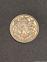 Reverse of 1941 Canadian silver 50 cents coin showing Canadian shield and supporting animals.