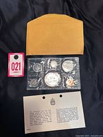 Original brown envelope, sealed plastic coin set with six coins, COA, and auction lot tag