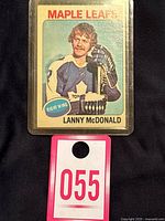 Front view of 1975-76 Topps hockey card of Lanny McDonald in Toronto Maple Leafs uniform with a wooden stick, card number 23 visible.