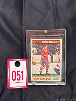 1977-78 O-Pee-Chee Guy Lafleur trading card in protective plastic case with lot tag number 051 visible.