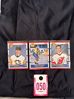Photo showing all three cards: Jaromir Jagr, Mats Sundin, and Martin Brodeur rookie cards laid out on black fabric, with a pink tag marked '050'