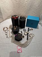 Overall view of mixed jewelry pieces on hex display stands and table