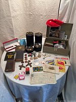 All contents laid out on table: jewelry, coins, keys, ephemera, film pack, book