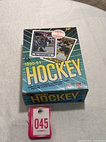 Photo of unopened box showing front with images of Bill Ranford and Ray Bourque cards, 45 cent price, and bilingual text in blue and yellow.