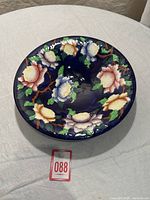 Top view showing the bowl's wide circular shape and handpainted multi-colored peonies on cobalt blue background.