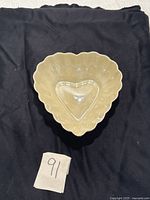Top view of vintage ivory heart shaped Belleek Ireland porcelain dish showing smooth interior and scalloped edges