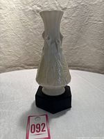 Front view of the vase showing the calla lily flowers and leaves in ivory and yellow porcelain.
