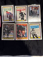 Set of six 1990-91 Wayne Gretzky O-Pee-Chee hockey collectible cards laid out on black background, front side showing various newspaper headline designs, Art Ross trophy card, All-Star portrait, and team photos.