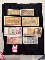 Eight banknotes on black cloth, full lot overview
