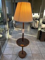 Full view of lamp turned on showing shade and side table