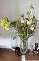 Full group of five vases placed on table with faux flowers inside the Mikasa vase