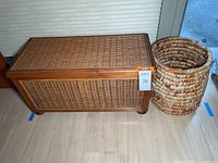 Woven wooden storage trunk beside woven natural fiber basket on floor