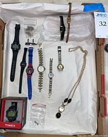 Photo showing assortment of 8 wristwatches laid out, including vintage Seiko, Timex Ironman models, Disney kids watch, and gold-tone necklace watch plus spare parts and cufflinks.