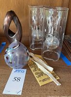 Close view of the Wolford hand-blown glass oil lamps with cylindrical glass chimneys, round reservoirs, and included extra wicks and original oil lamp packaging label.