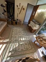 Photo of the woven rug laid out showing its full size and pattern in a room setting.