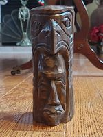 Front view of the ceramic totem showing Thunderbird mask atop and human face beneath with carved details.