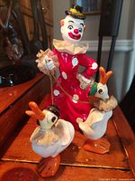 Front view of vintage Japanese ceramic clown figurine with two geese holding leashes